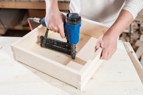 carpenter nailing a cabinet drawer