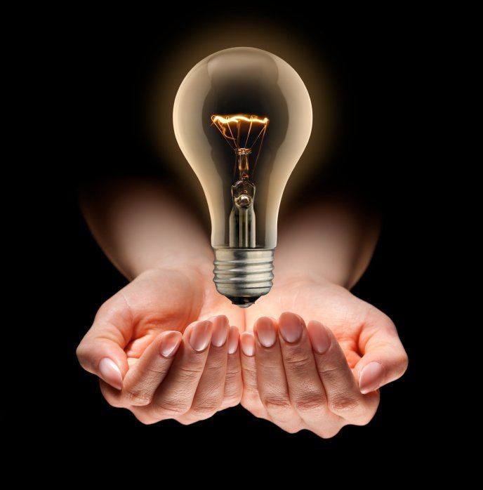 a person holding a light bulb in their hands