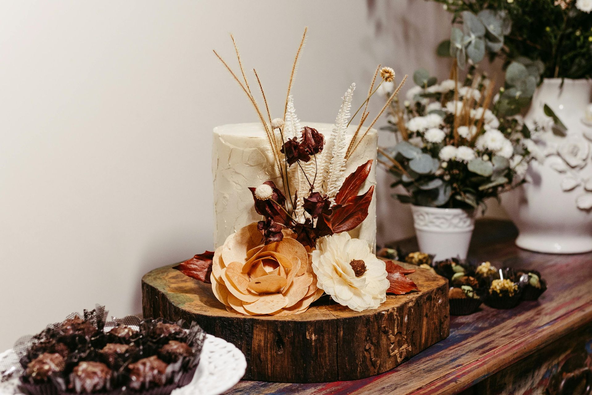 A wedding cake with flowers on top is on a table