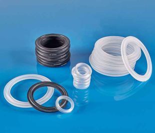 Various sizes and colors of rubber O-rings and gaskets, stacked and scattered on a blue surface.