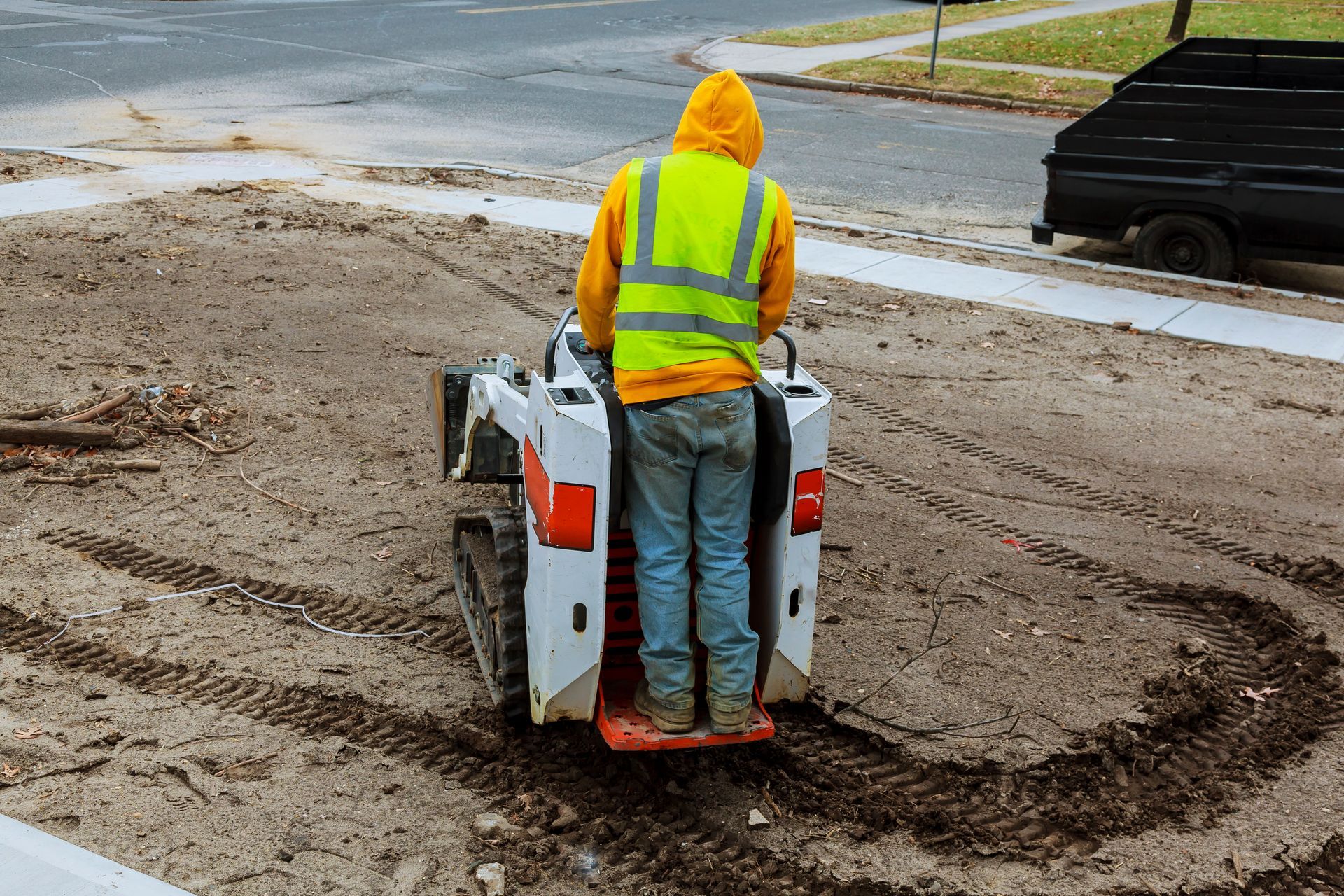 A small excavator works on the street