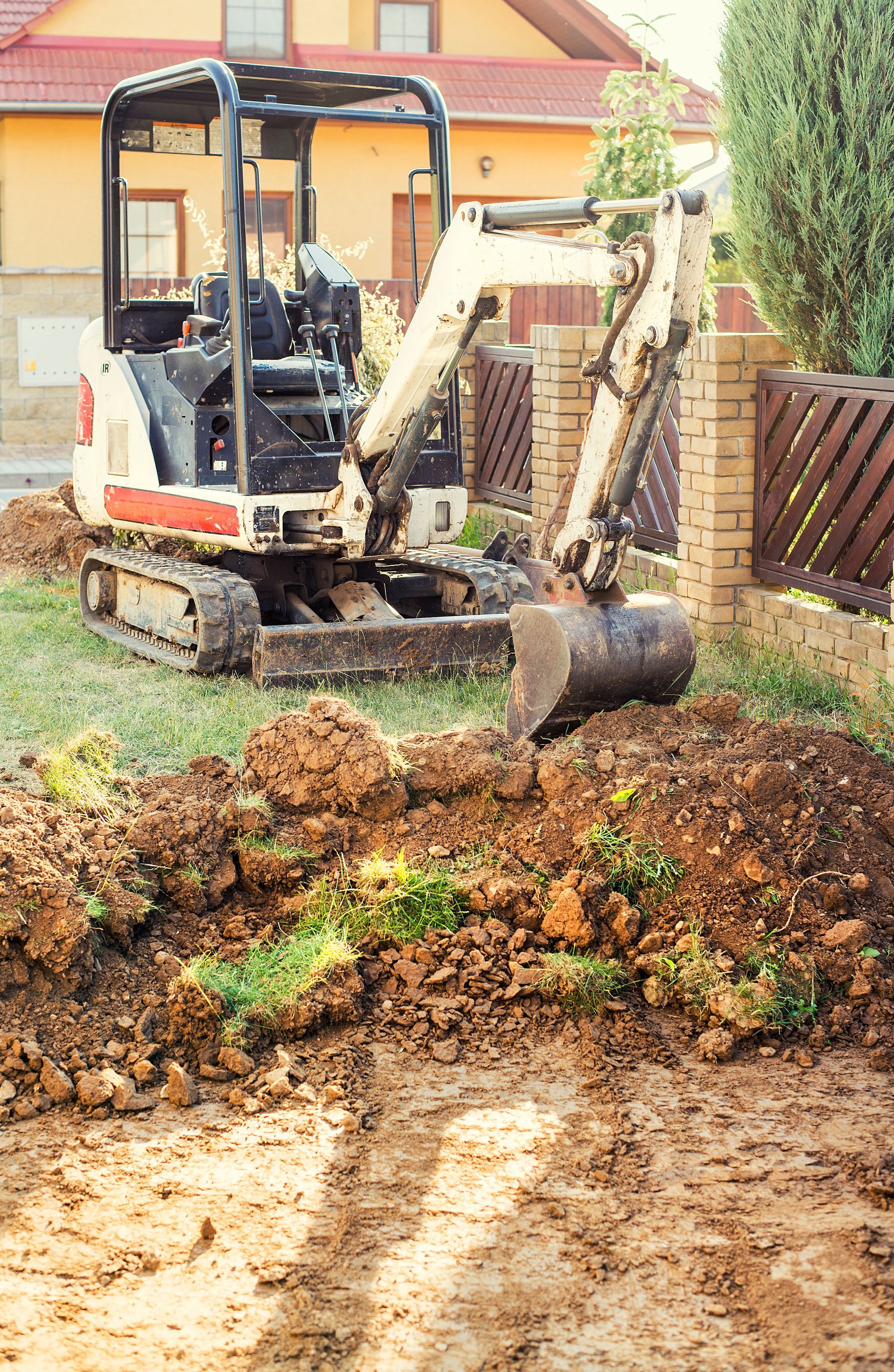 Excavator regulates the terrain around the house