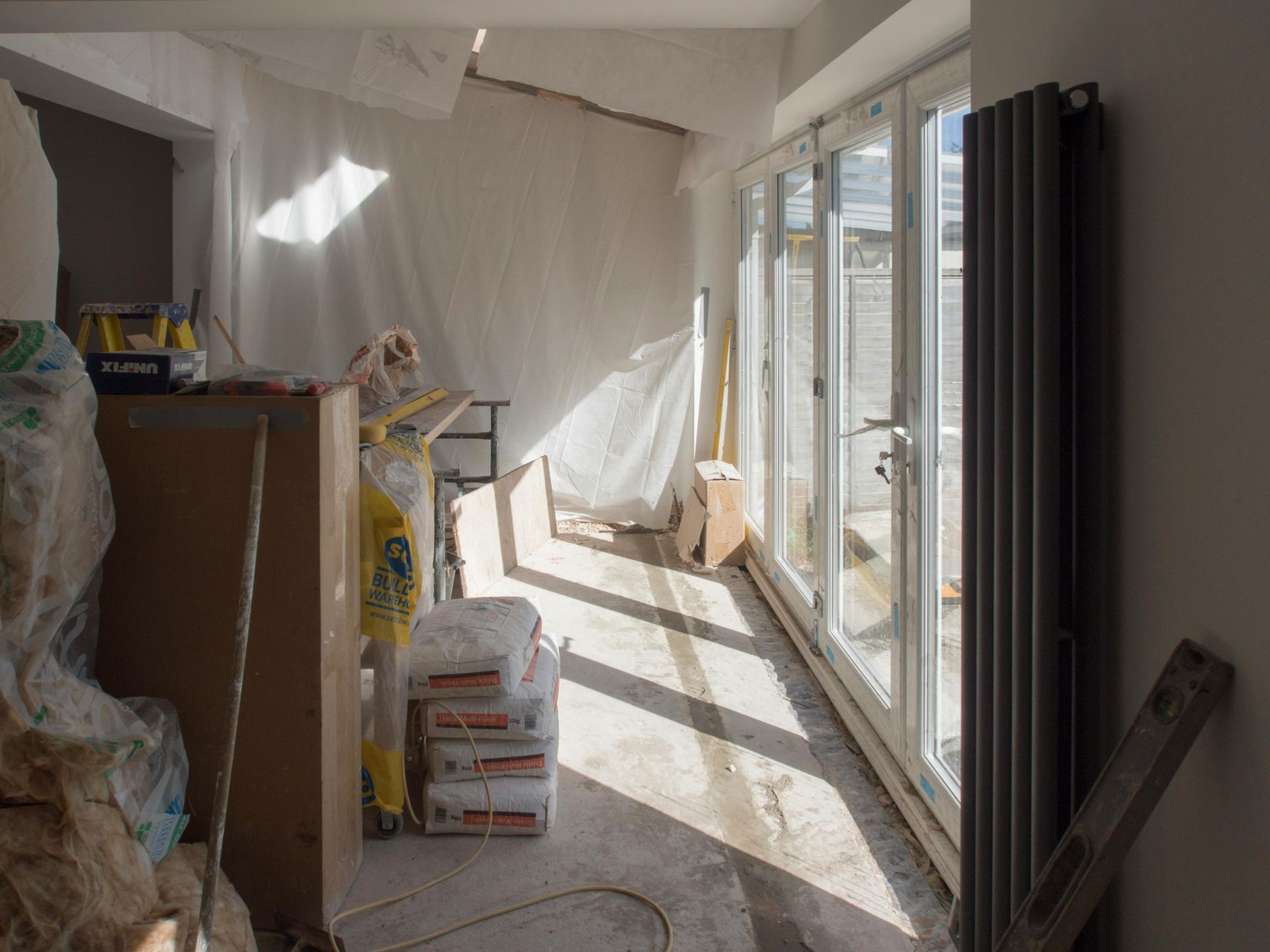 A room with a lot of boxes on the floor and a lot of windows.