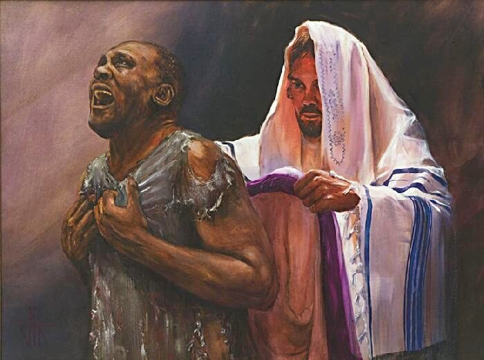 Man in tattered clothes cries out as another, cloaked in white, reaches out, indoors.