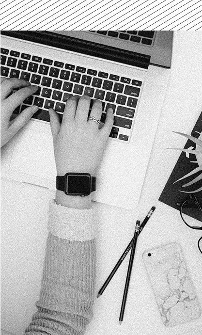 A person is typing on a laptop computer while wearing a watch.