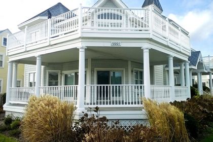 A large white house with a large porch has the number 4163 on the front