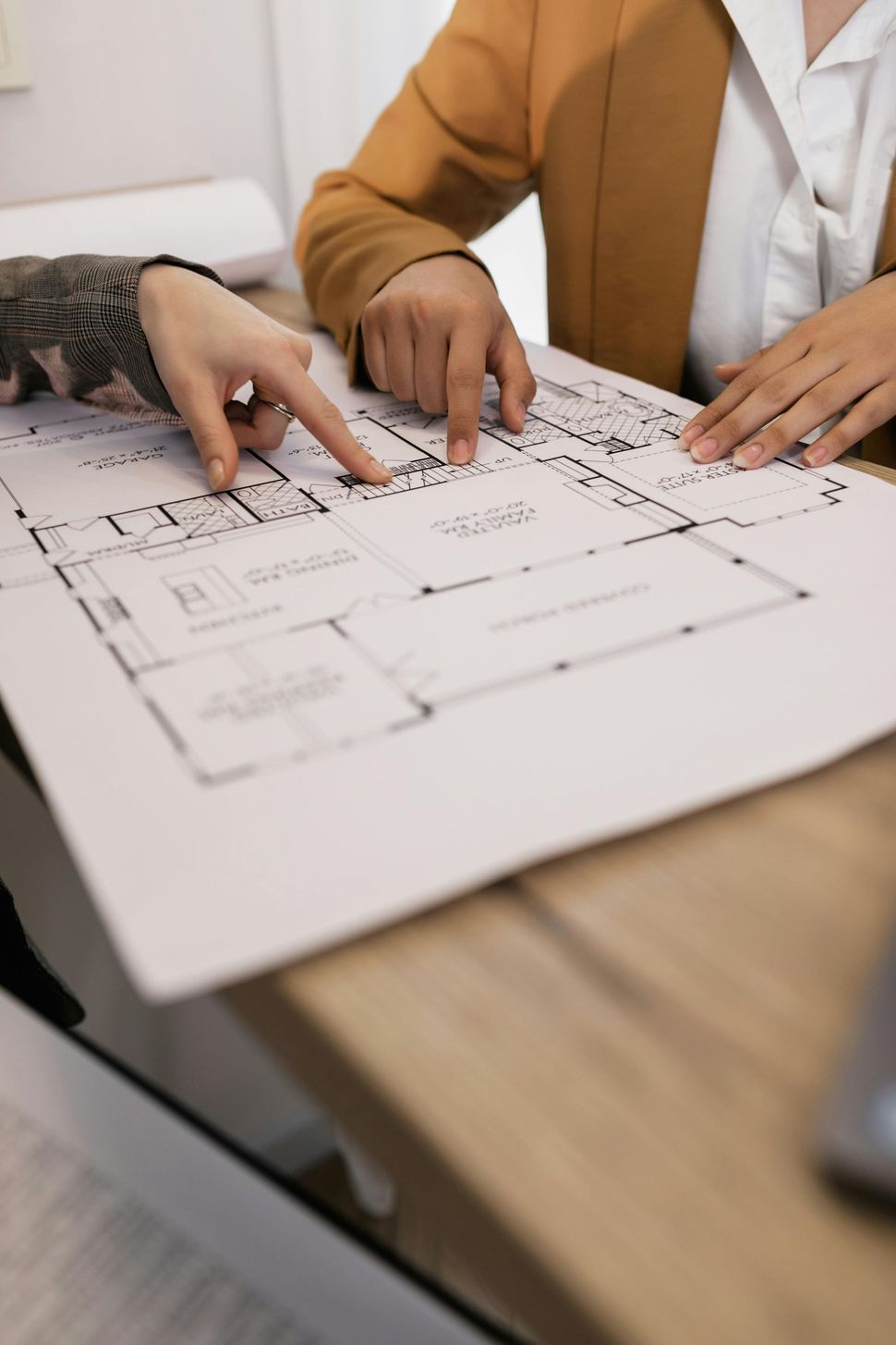 Two people are sitting at a table looking at a floor plan.