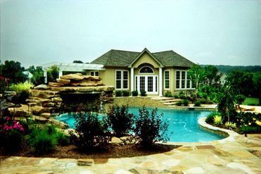 A large house with a swimming pool in front of it