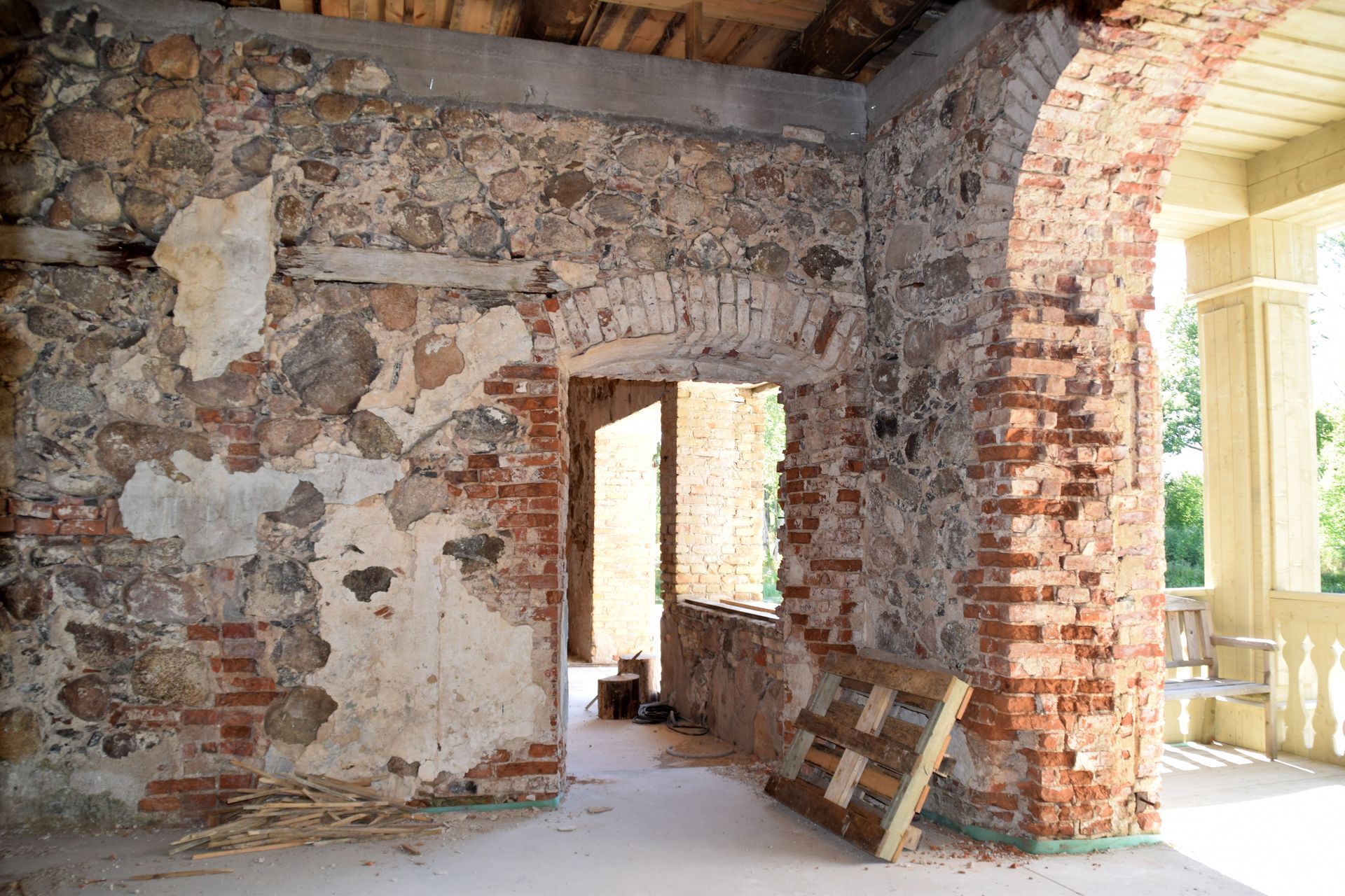 A room with brick walls and a wooden pallet on the floor.