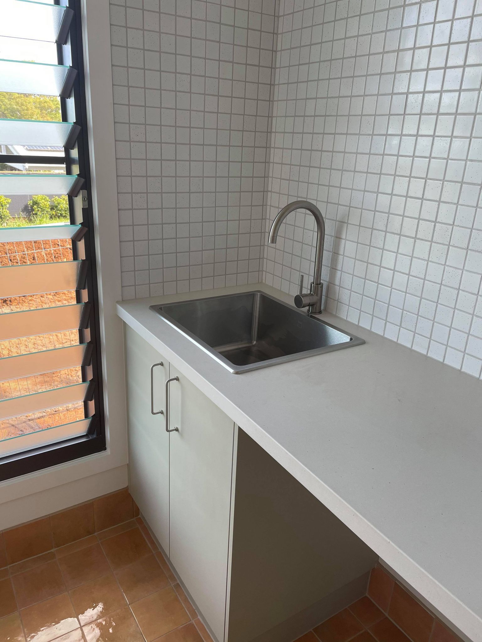 a kitchen with a sink , cabinets and a window .