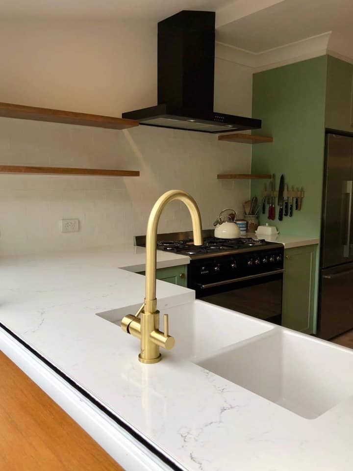 A kitchen with a sink and a stove top oven