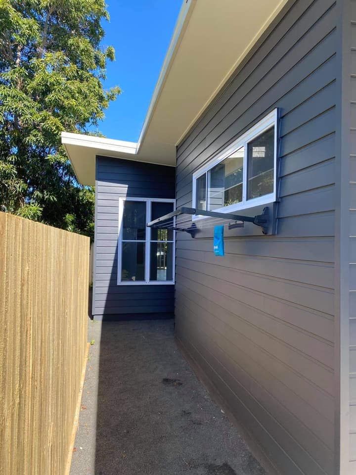 A house with a fence and a window on the side of it.