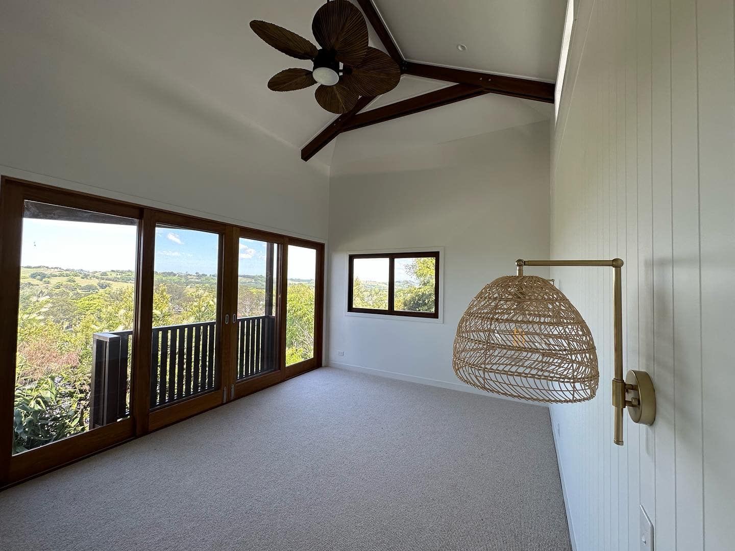 An empty room with a ceiling fan and a lamp.