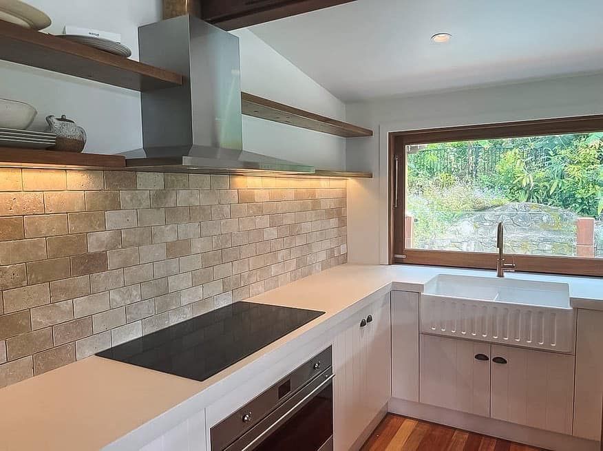 A kitchen with a stove top oven and a sink
