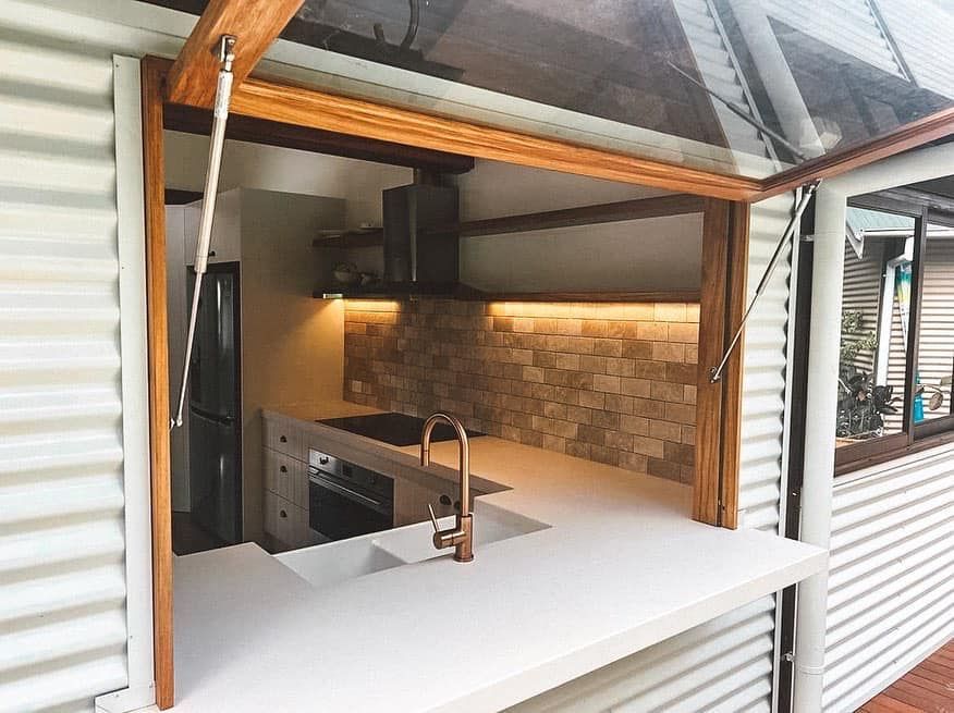 A kitchen with a sink , stove and refrigerator.
