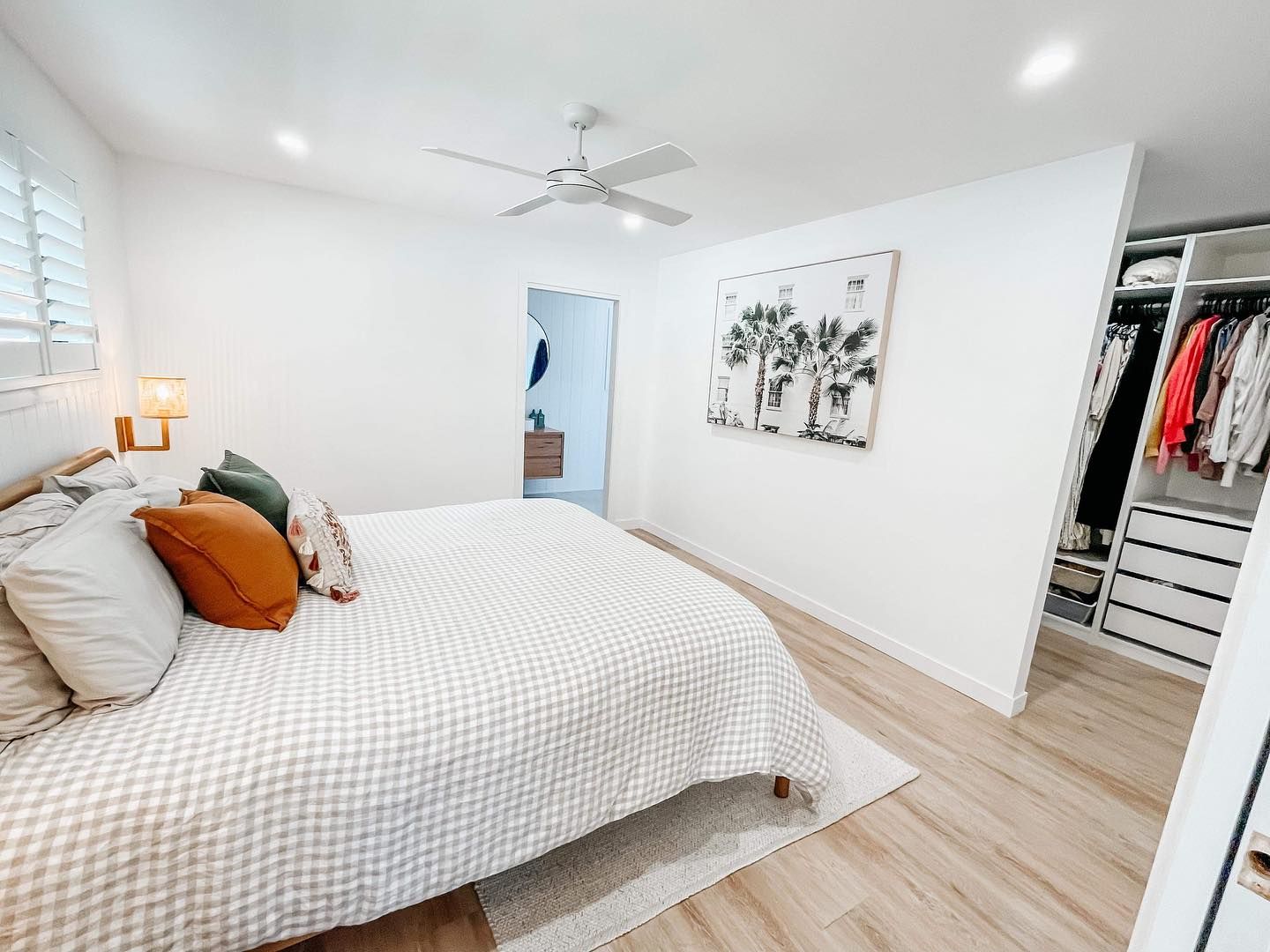 A bedroom with a large bed and a walk in closet.