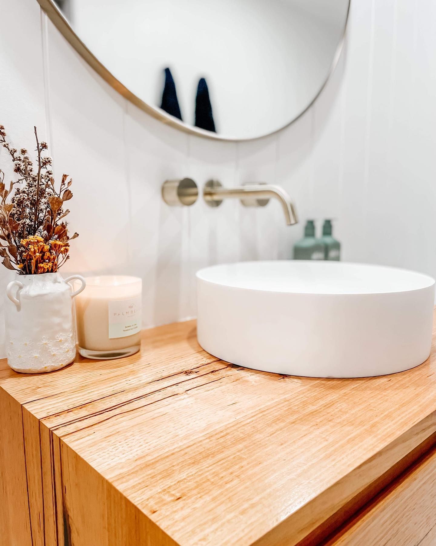 A bathroom with a round sink and a mirror