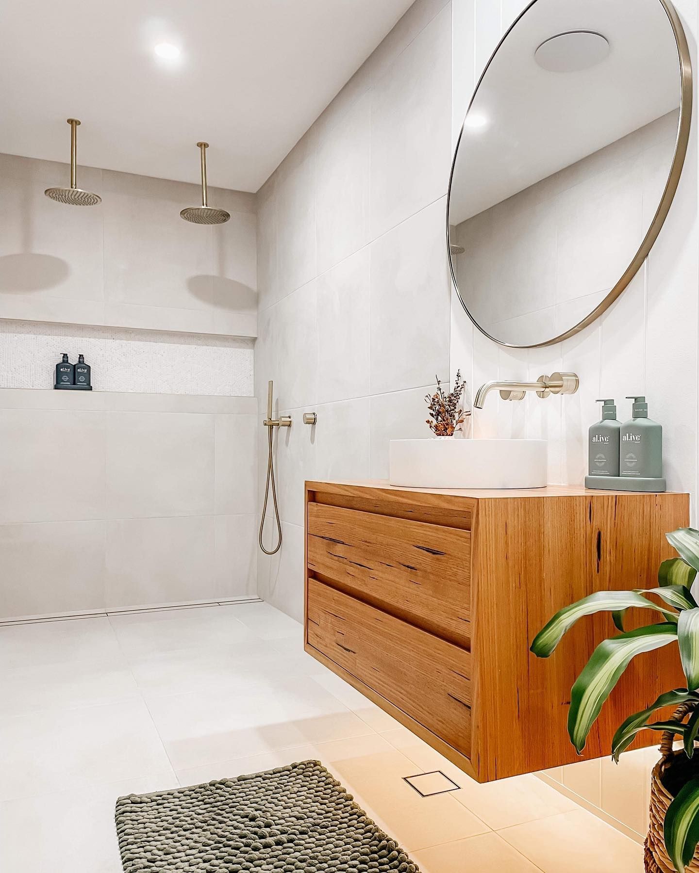 A bathroom with a sink , mirror and shower.