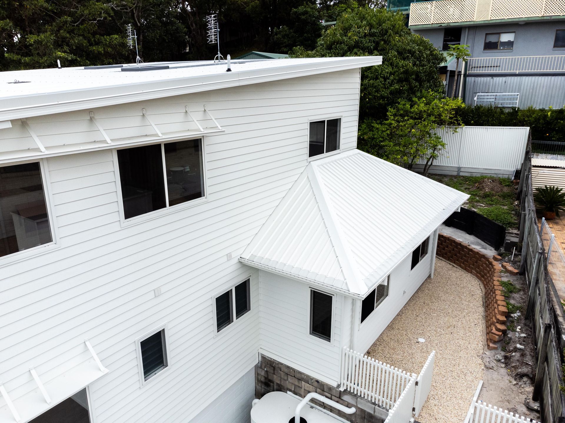 An aerial view of a white house with a white roof