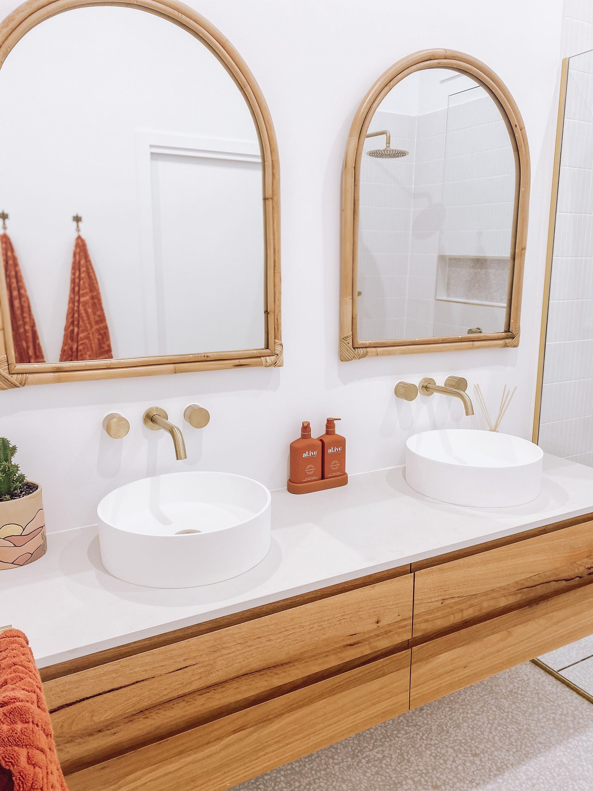 A bathroom with two sinks and two mirrors.