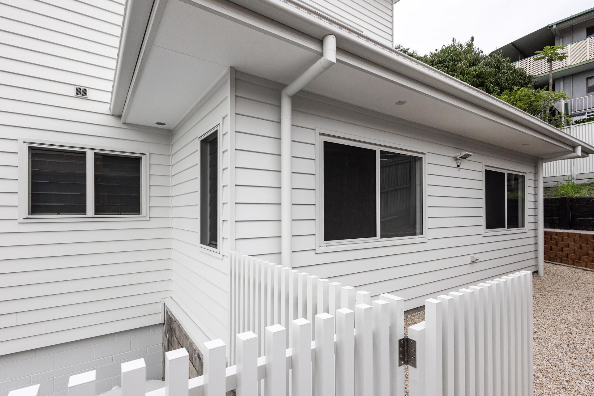 A white house with a white picket fence in front of it