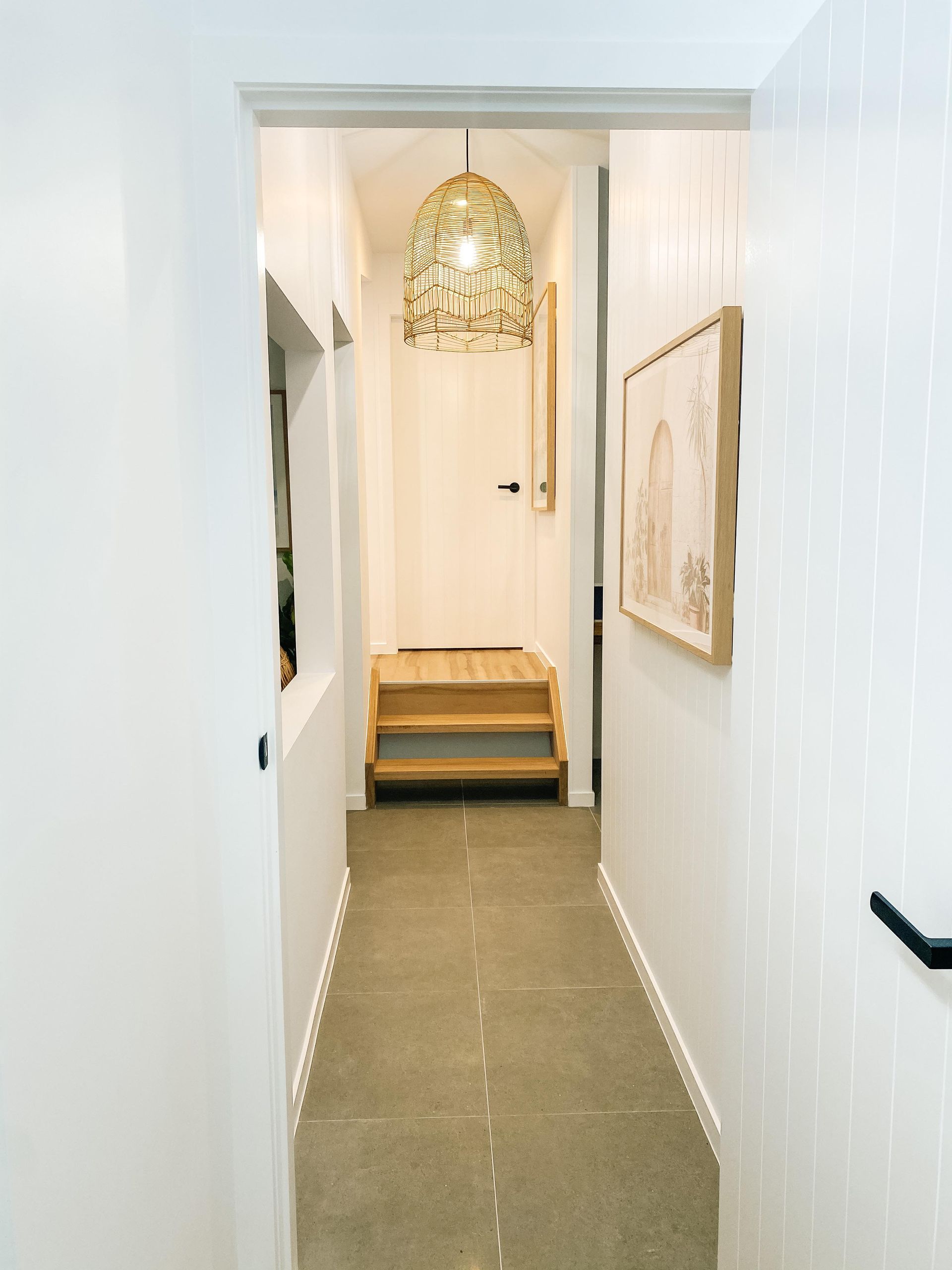 A hallway with stairs and a picture on the wall