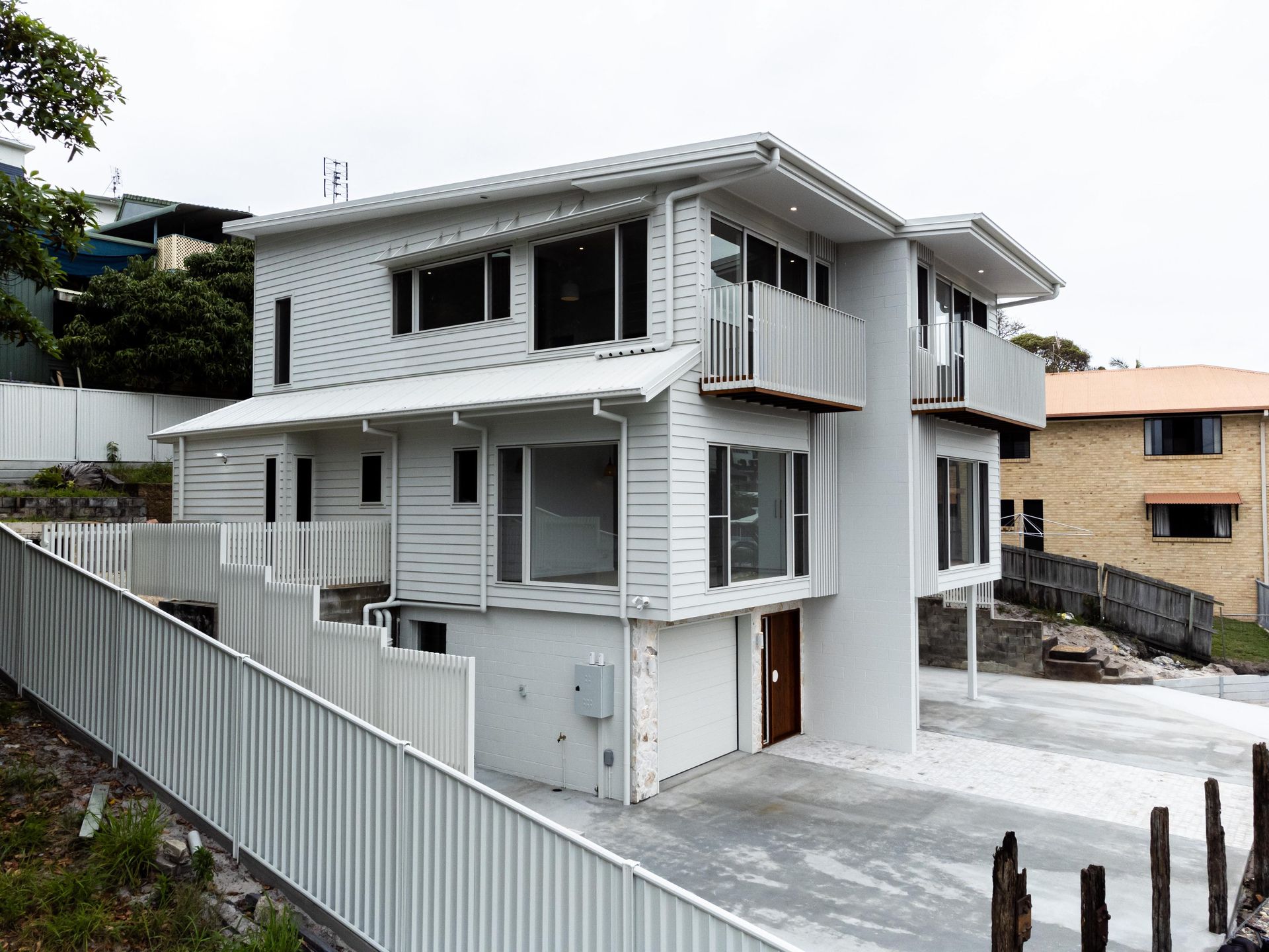 A large white house with a white fence in front of it.