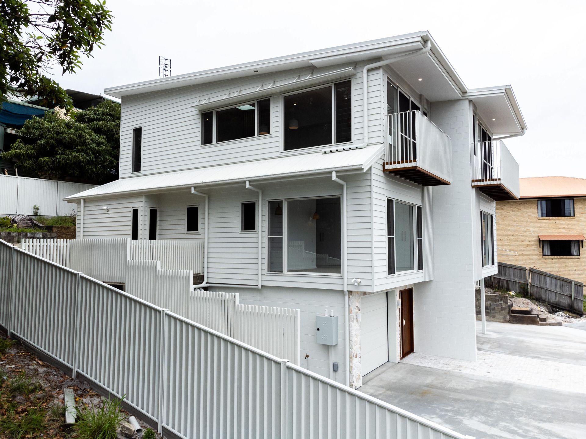 A white house with a white fence in front of it