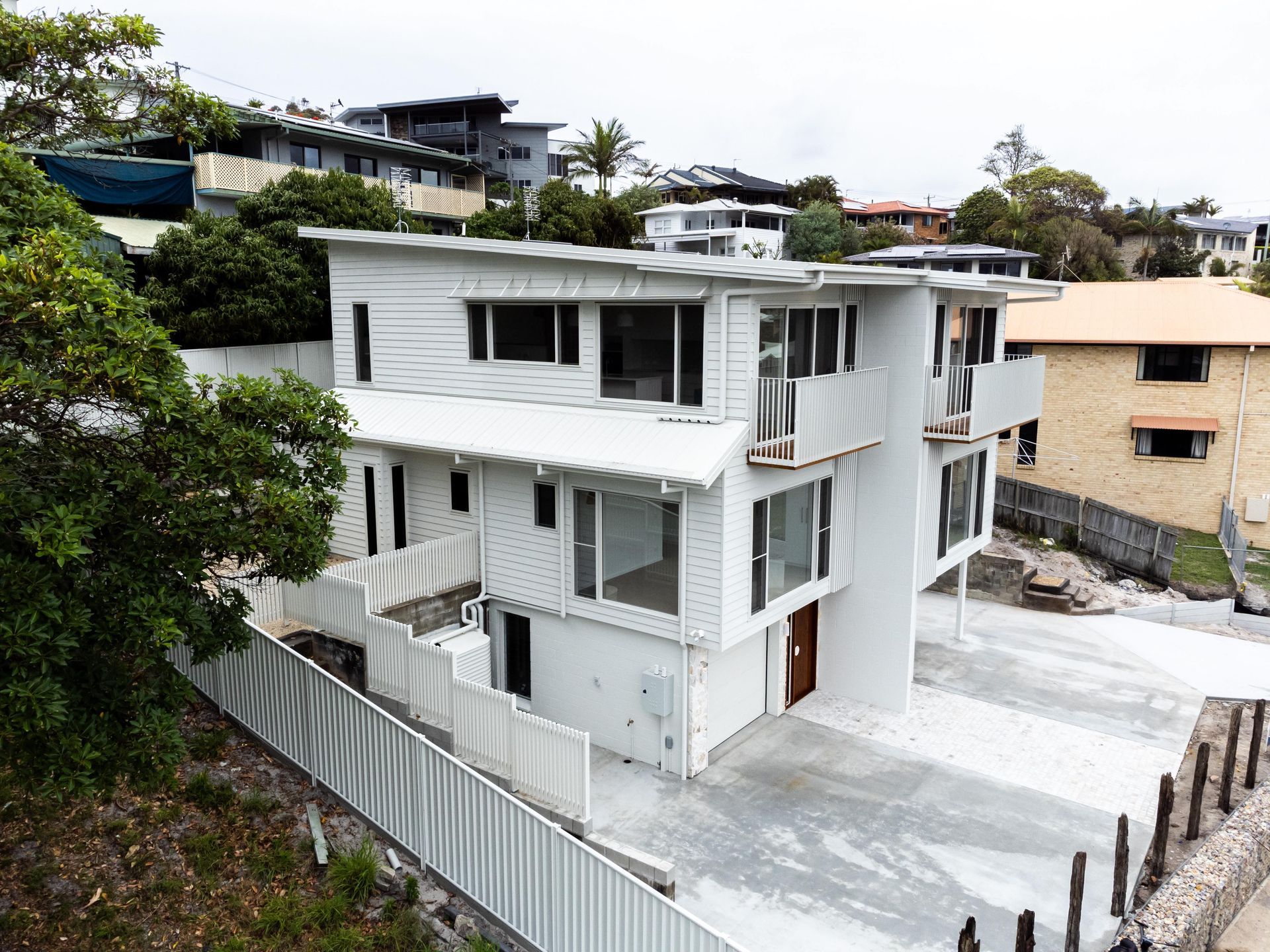 A large white house is sitting on top of a hill.