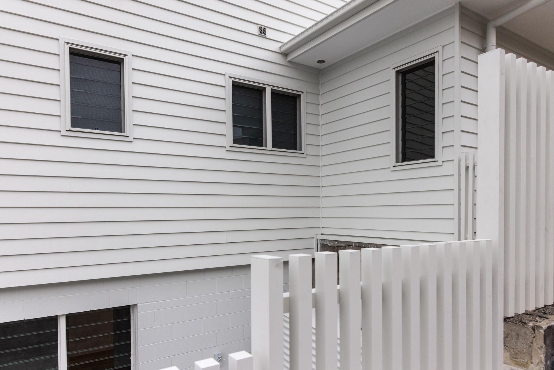 A white house with a white fence in front of it