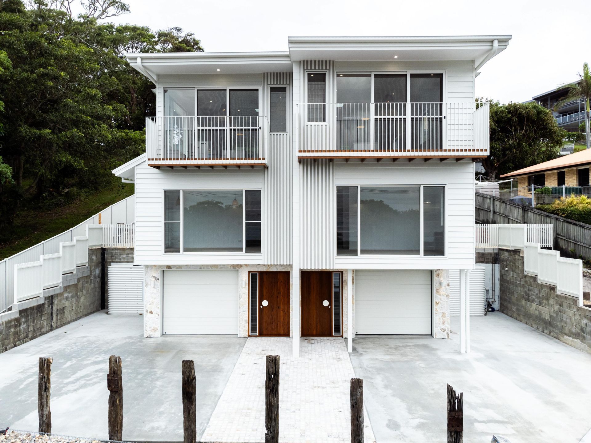 A large white house with two garages and two balconies