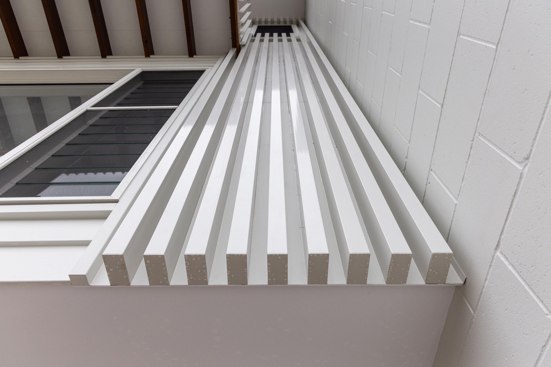 A white wall with a row of white stripes on it.