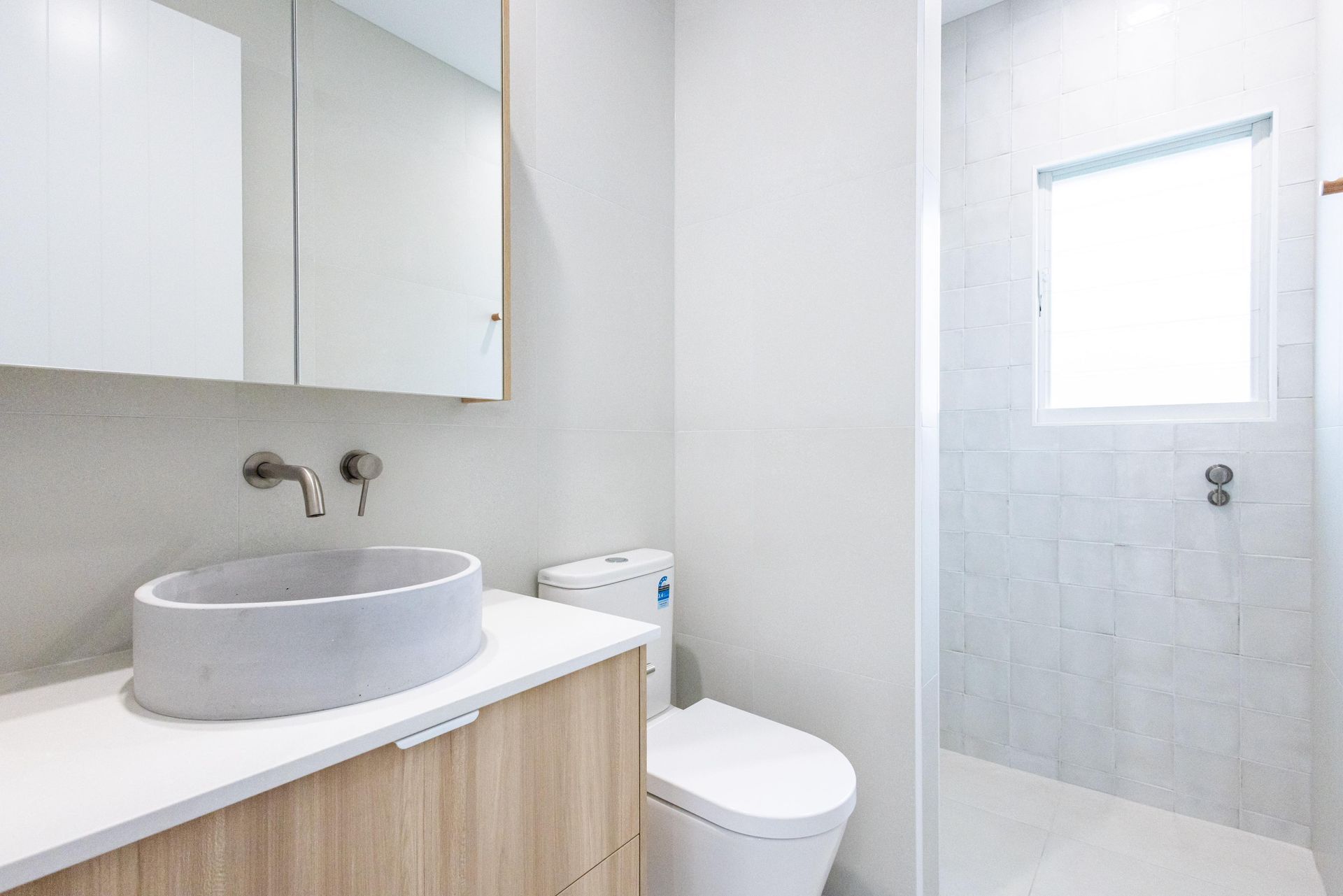 A bathroom with a sink , toilet and shower.