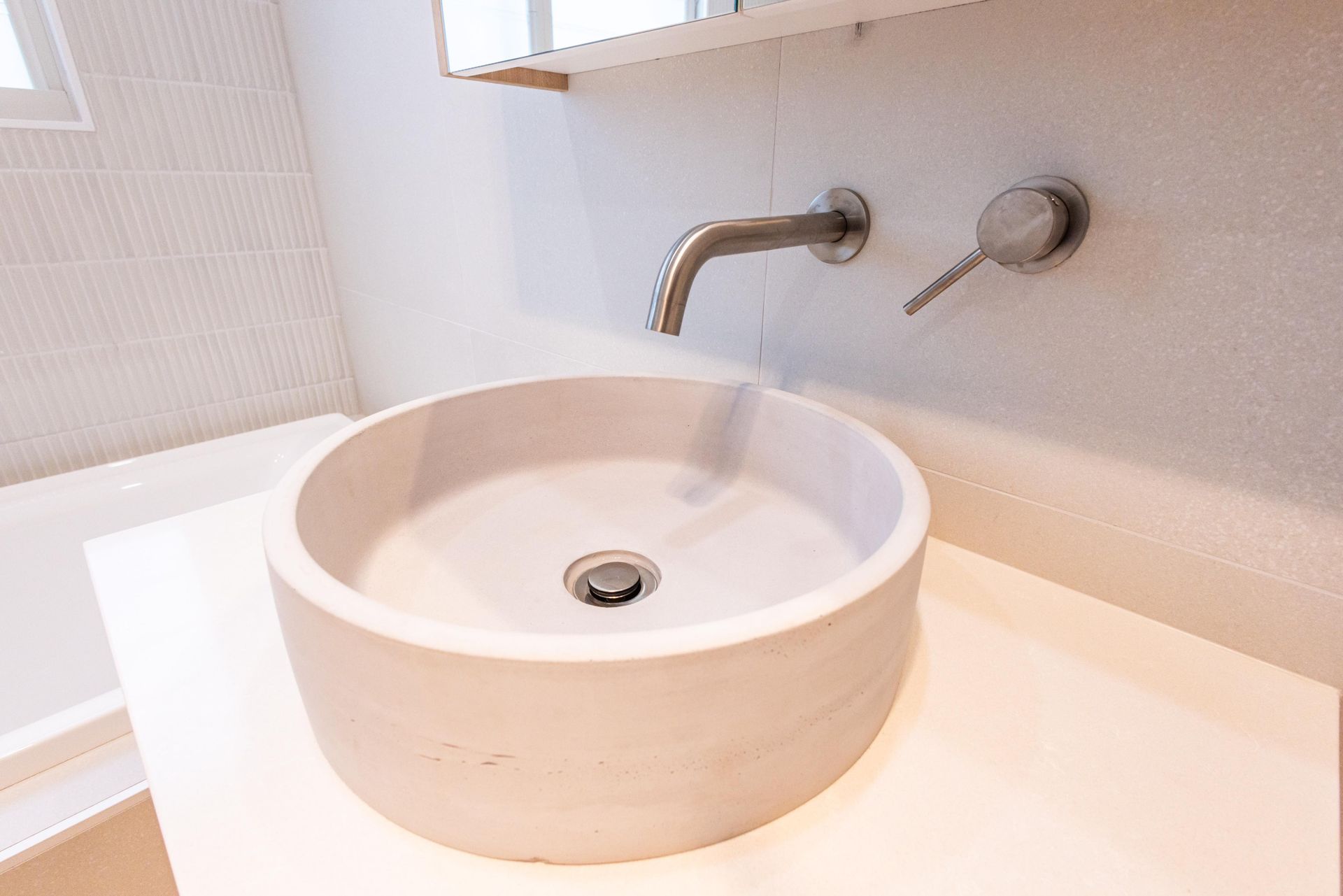 A bathroom sink with a faucet on the wall.