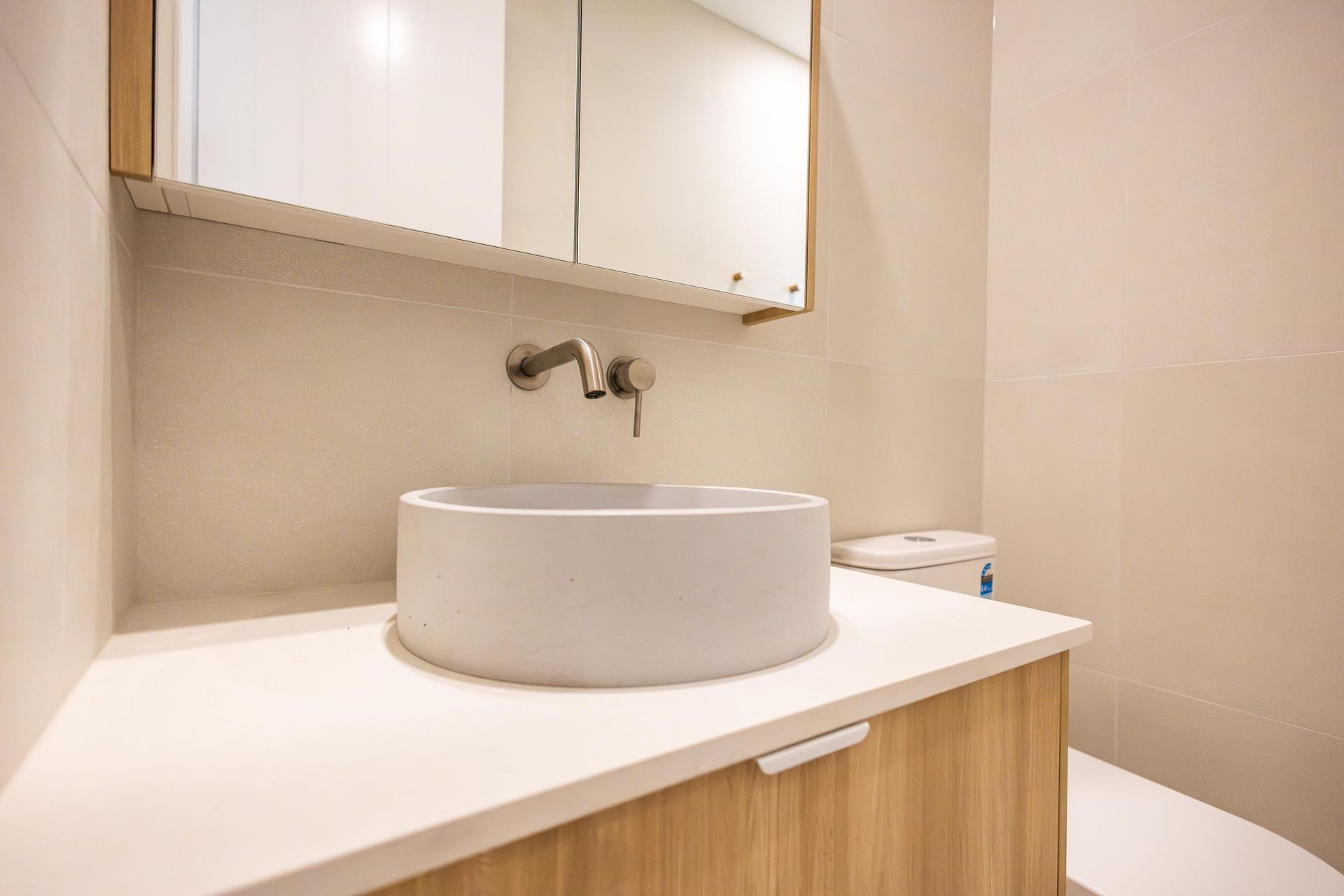 A bathroom with a sink , toilet and mirror.
