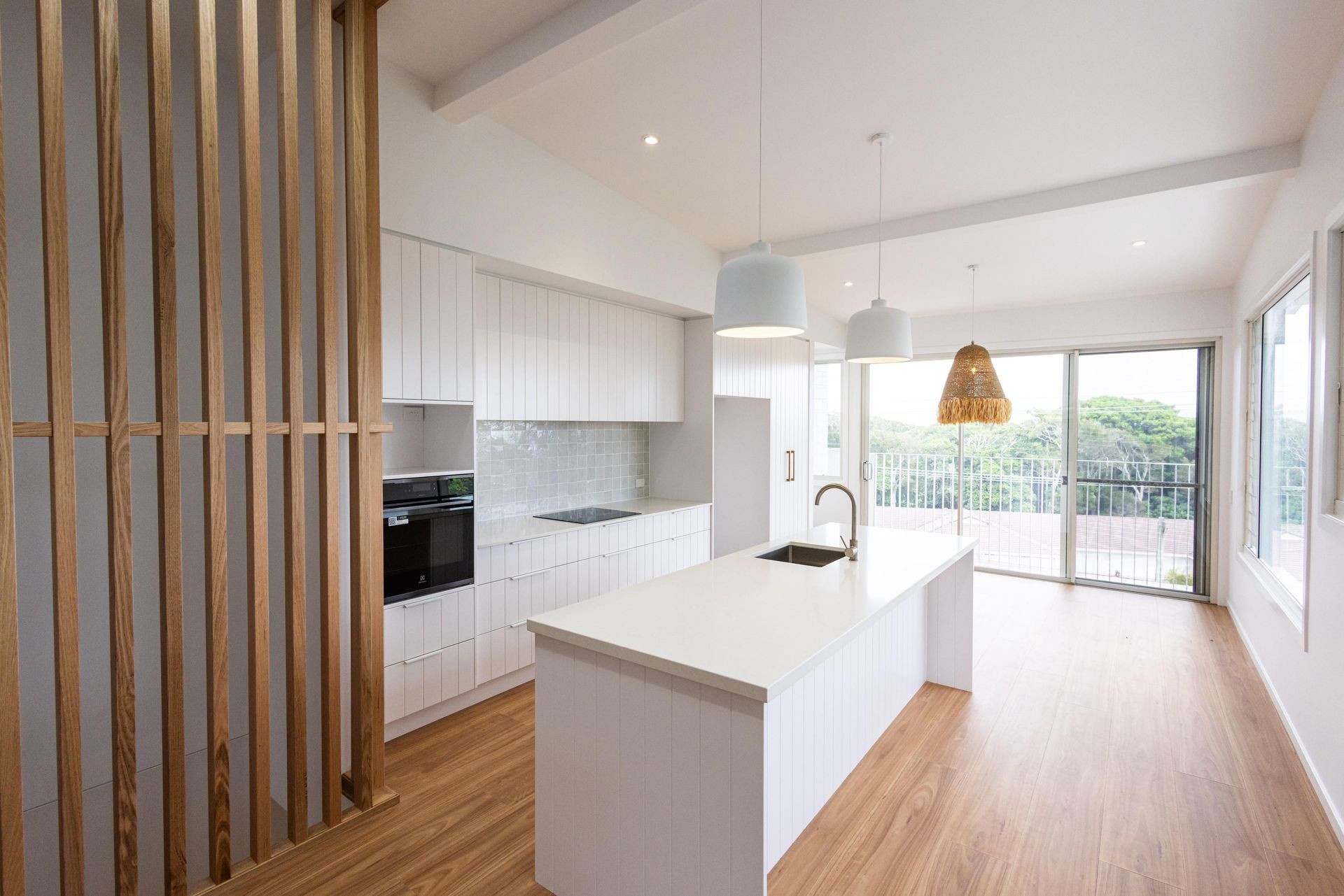 A kitchen with white cabinets and a large island in the middle of the room.