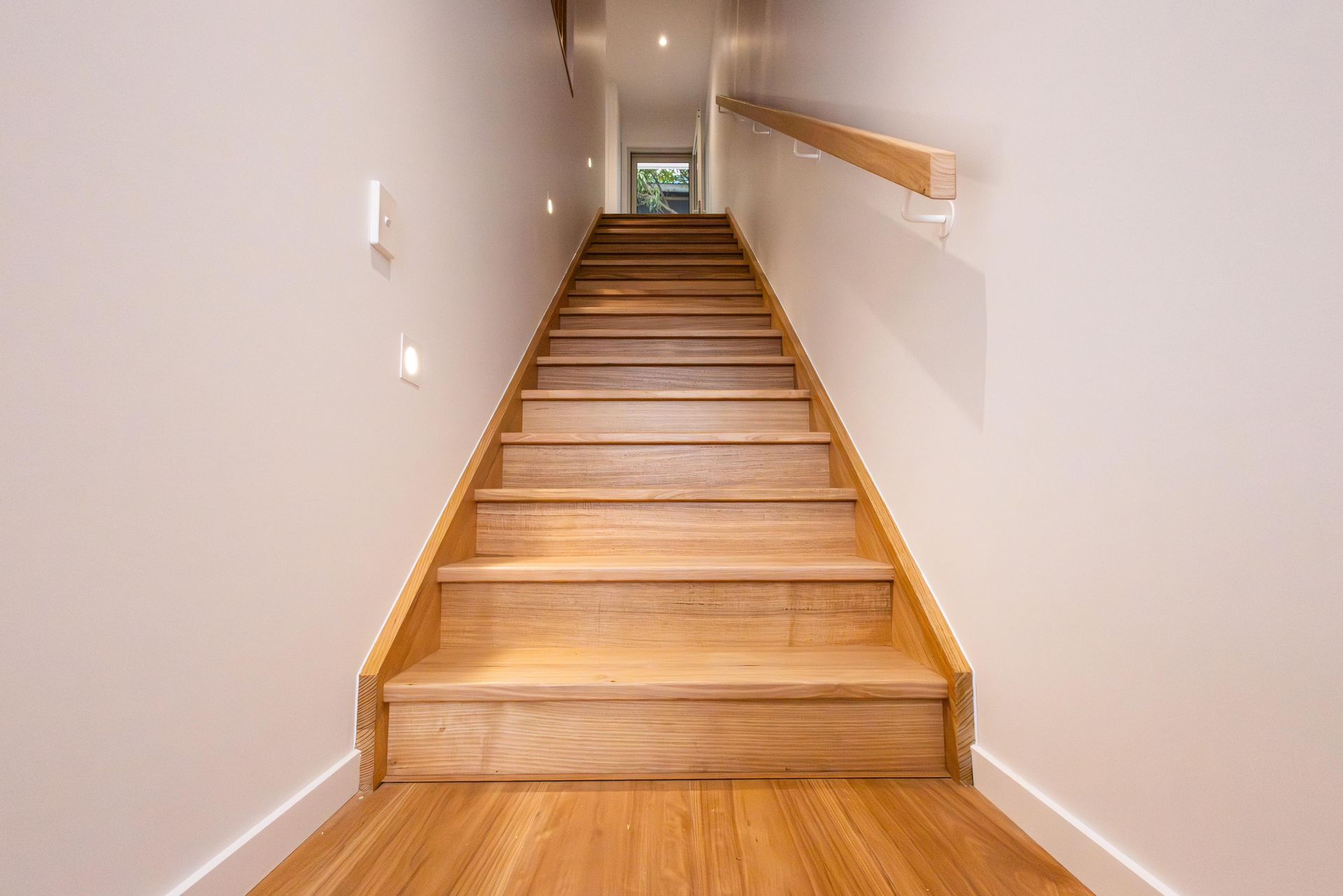A set of wooden stairs leading up to the second floor of a house.