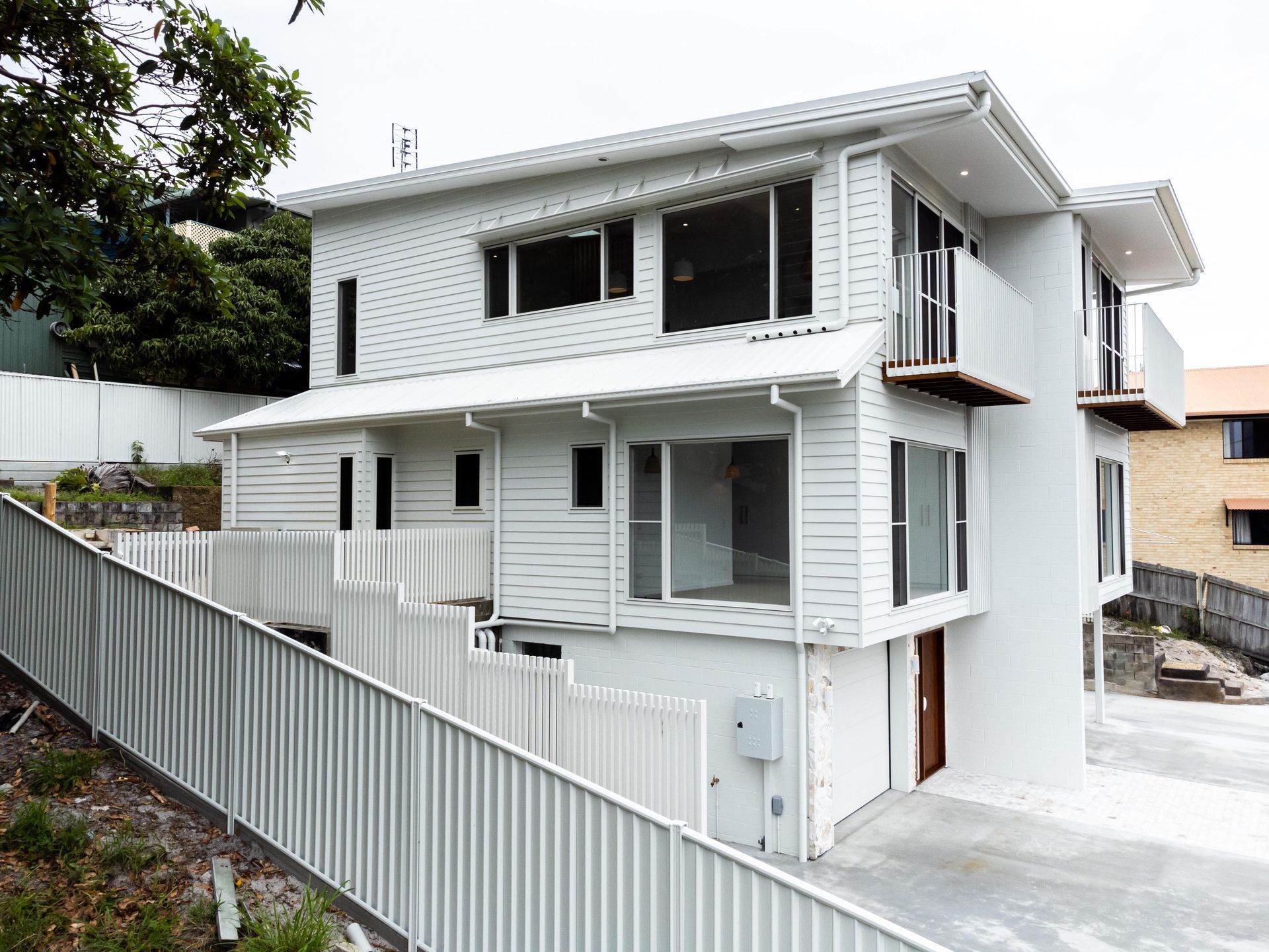 A large white house with a white fence around it.