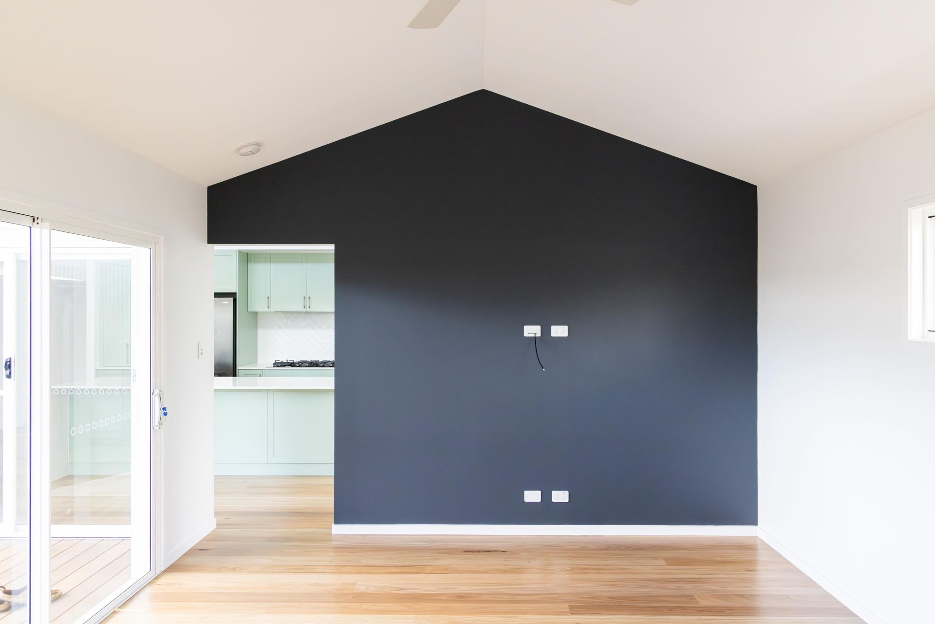 An empty room with a black wall and a vaulted ceiling