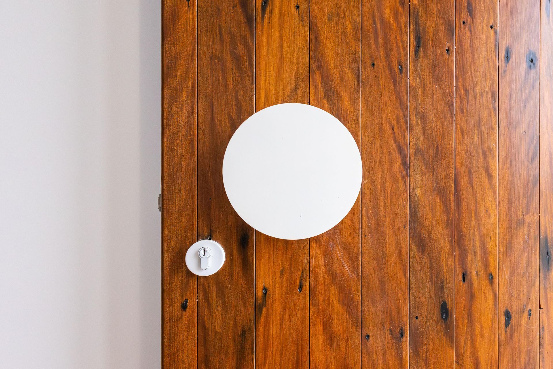 A wooden door with a white circle in the middle of it.