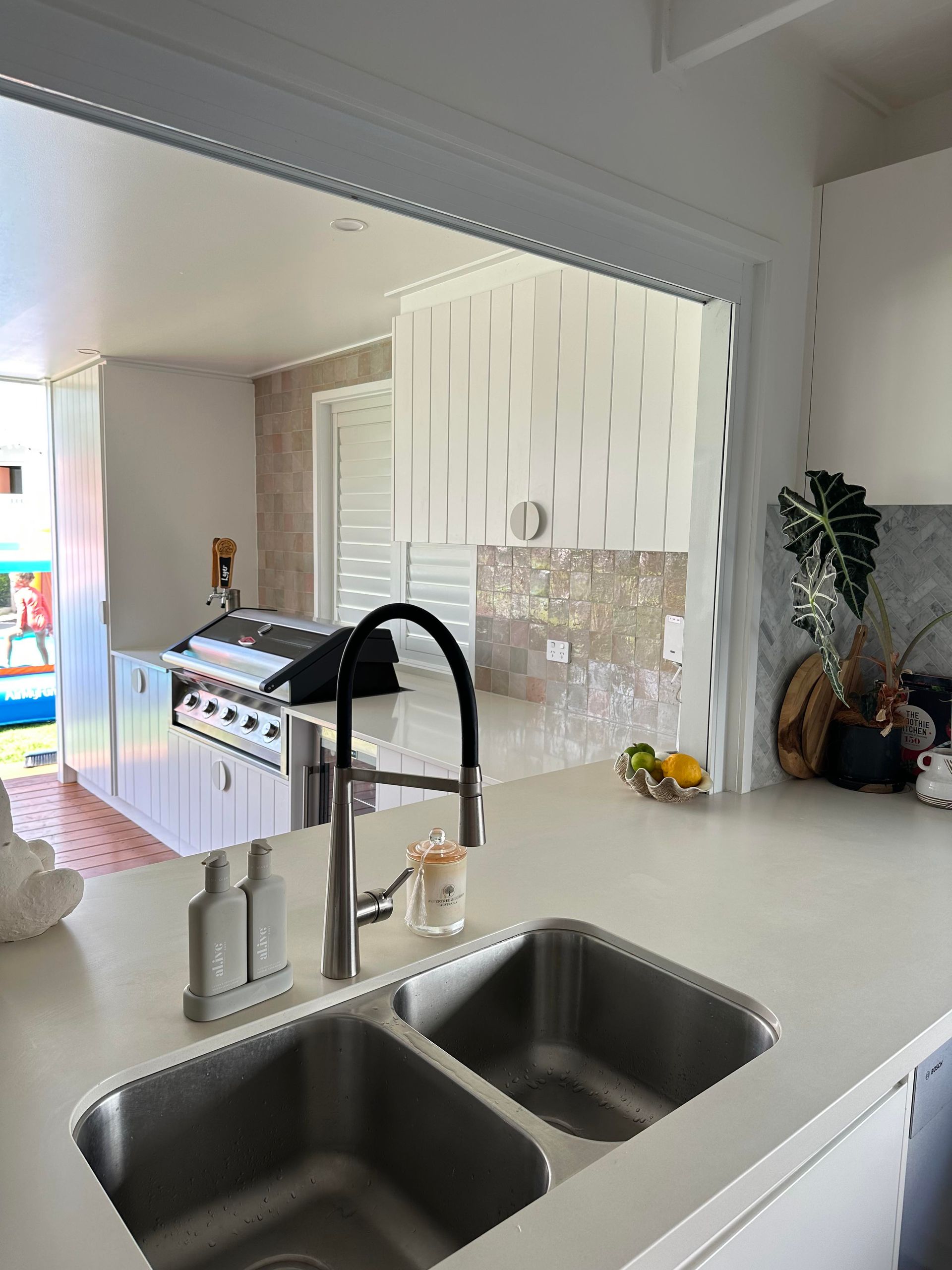 A kitchen with two sinks , a faucet and a grill.