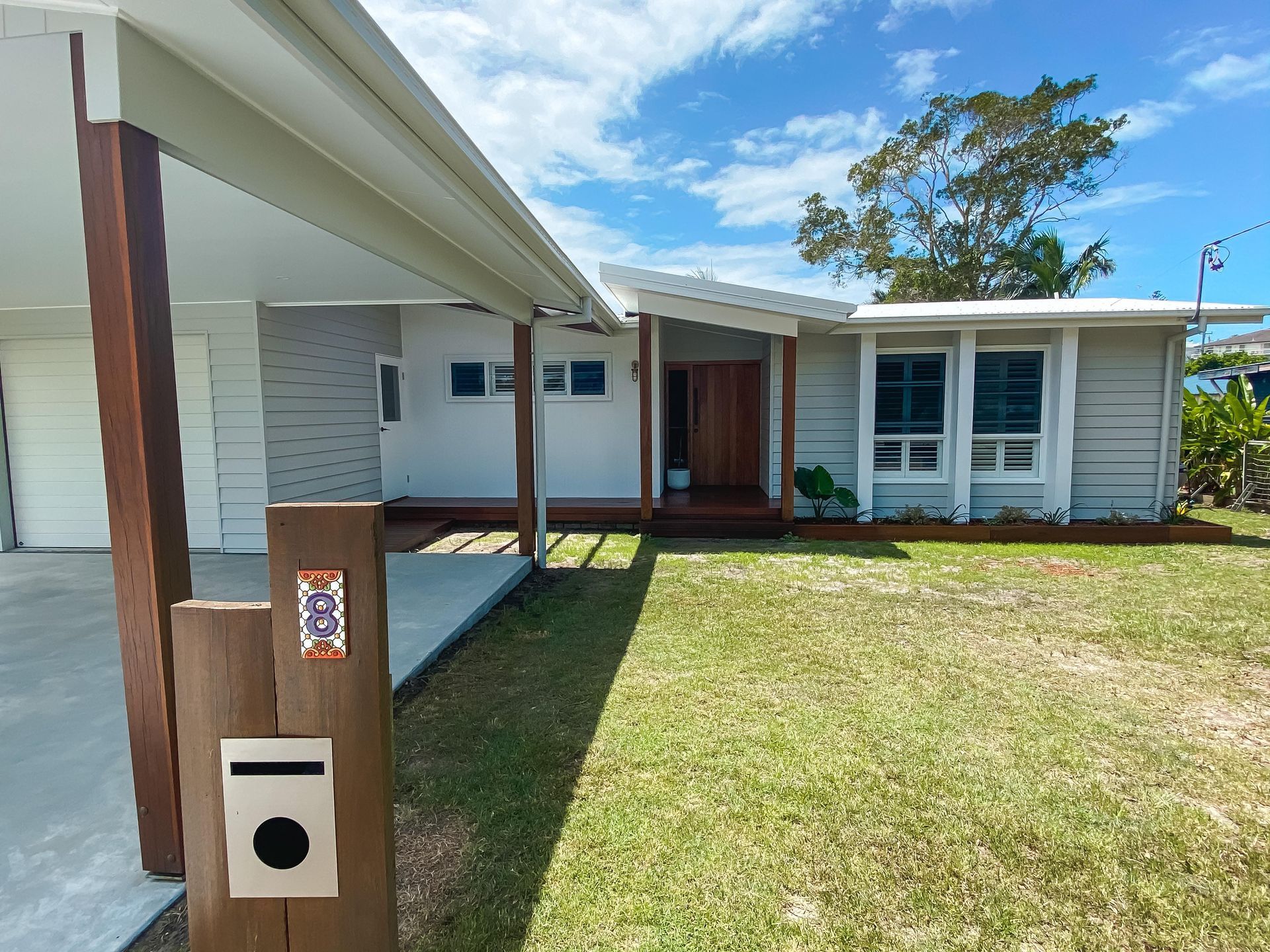 A white house with a wooden mailbox in front of it