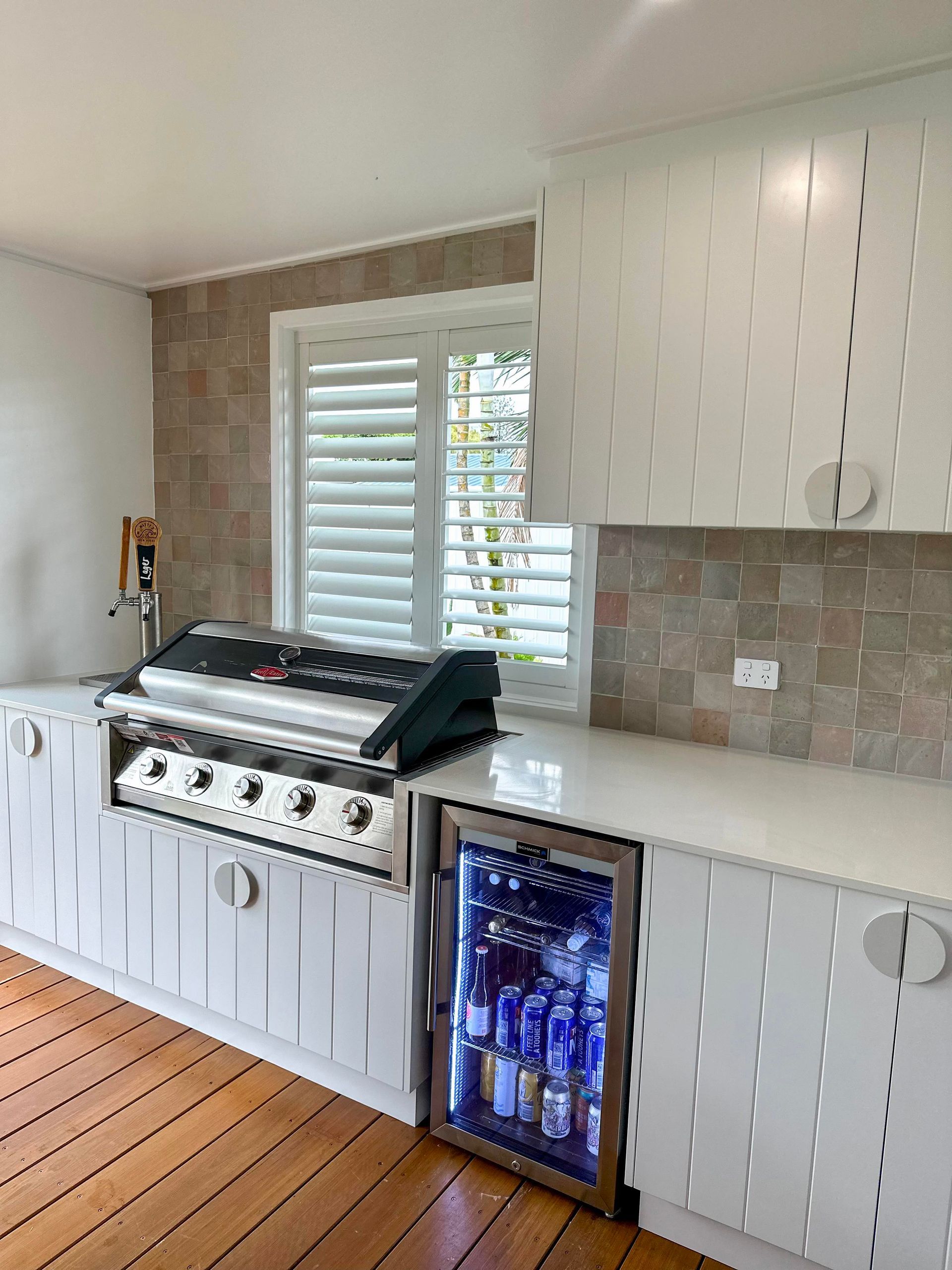 A kitchen with a grill and a refrigerator.