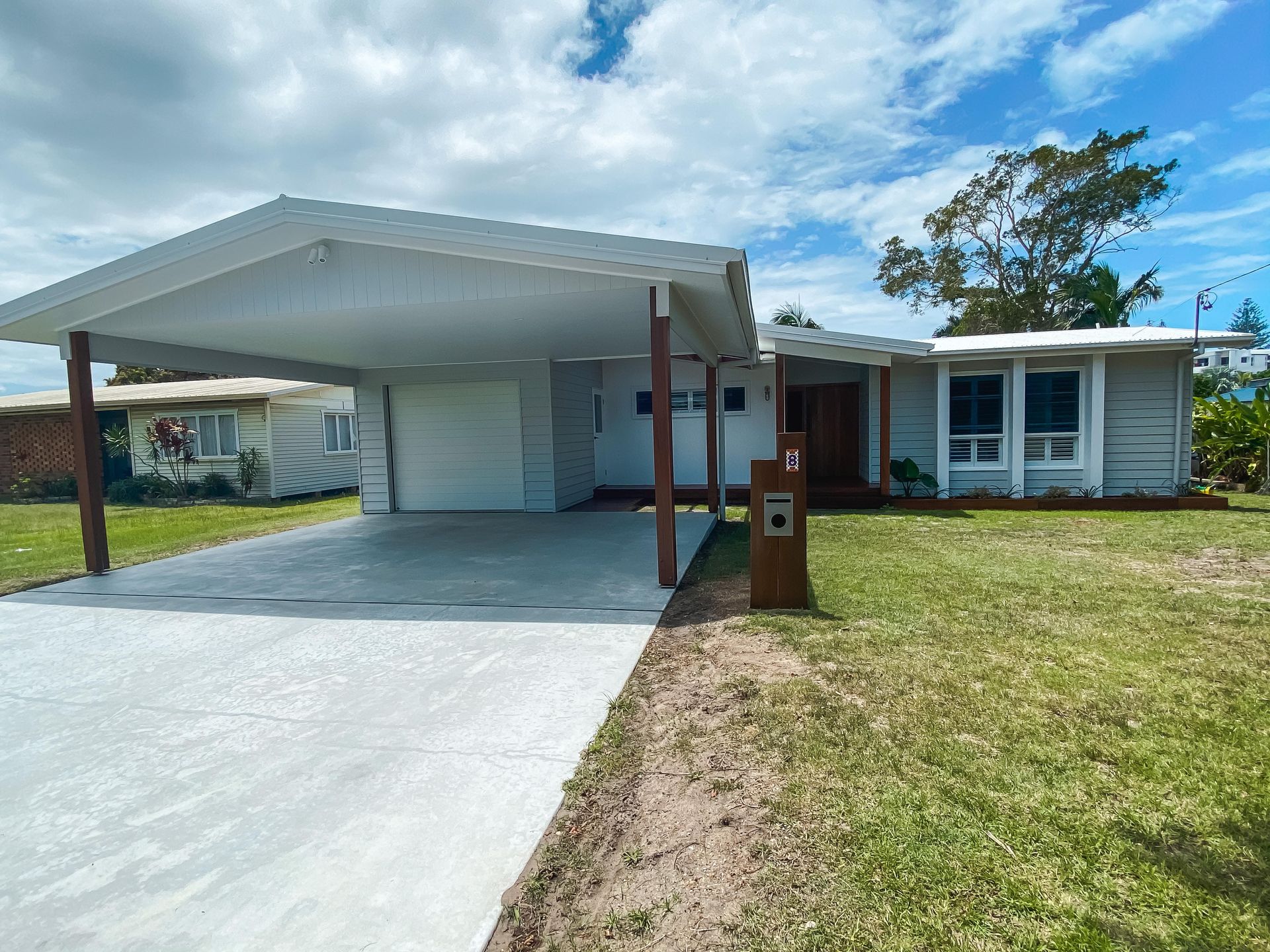 A house with a carport and a driveway in front of it.