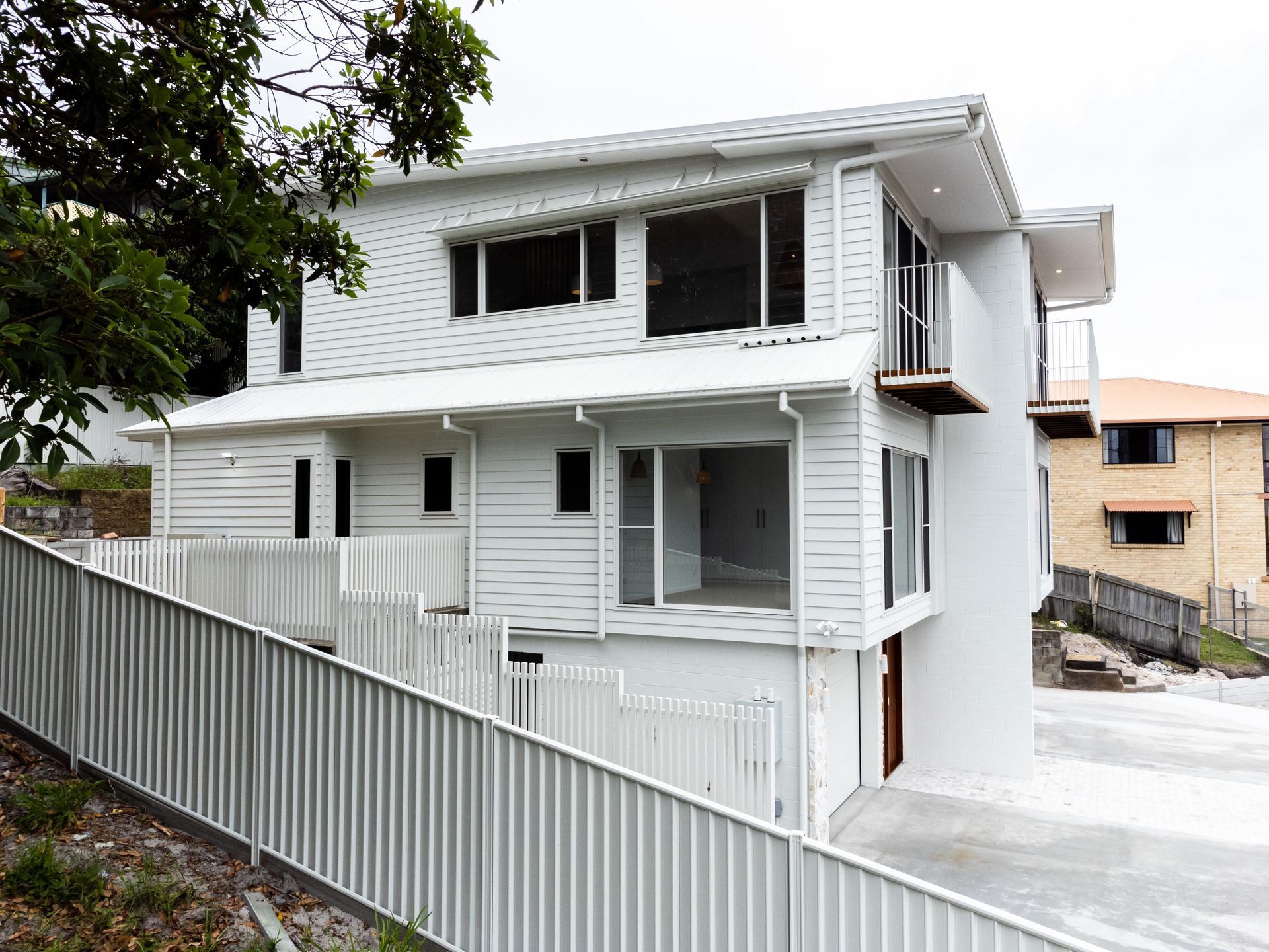 A white house with a white fence in front of it