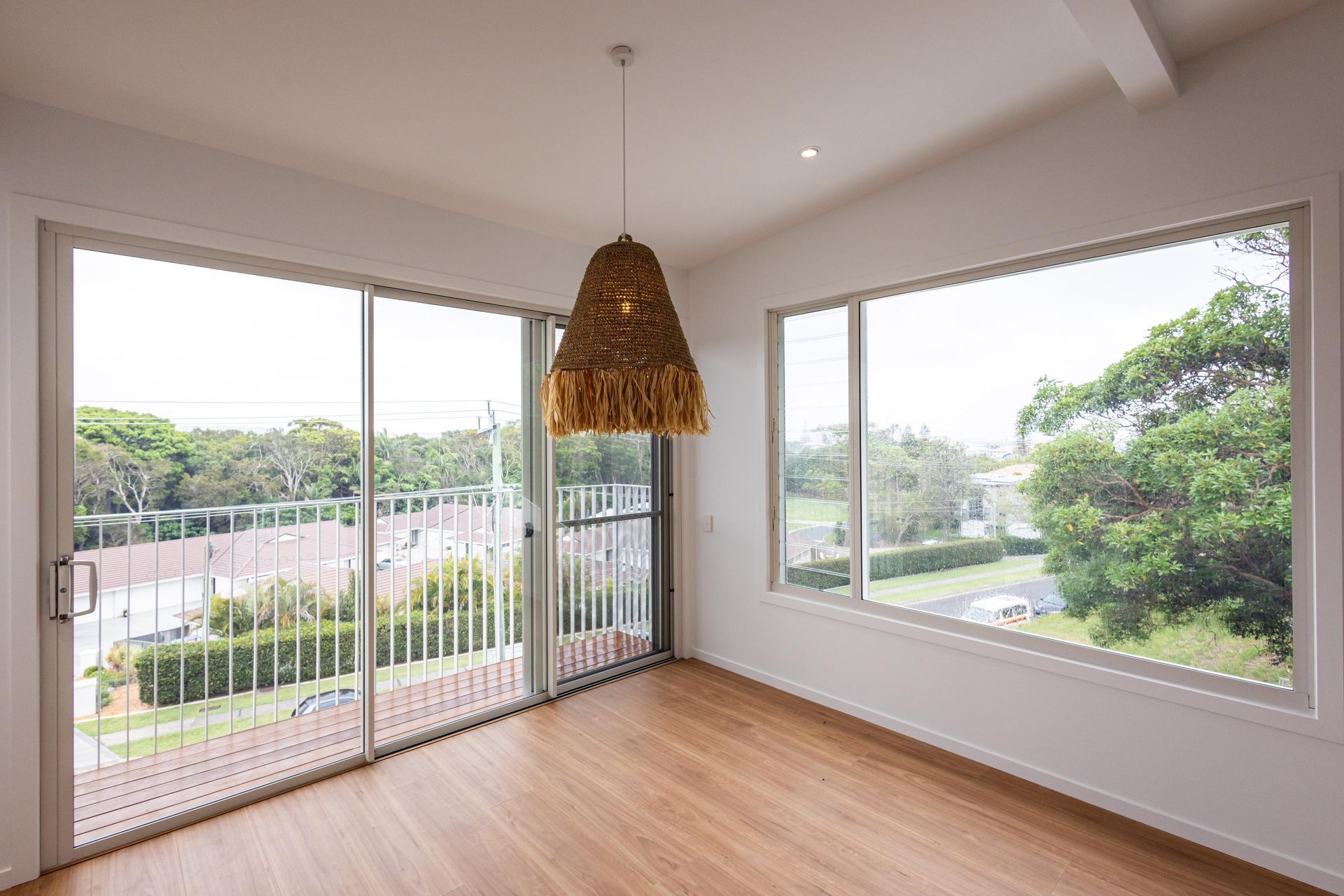 An empty room with sliding glass doors and a balcony.