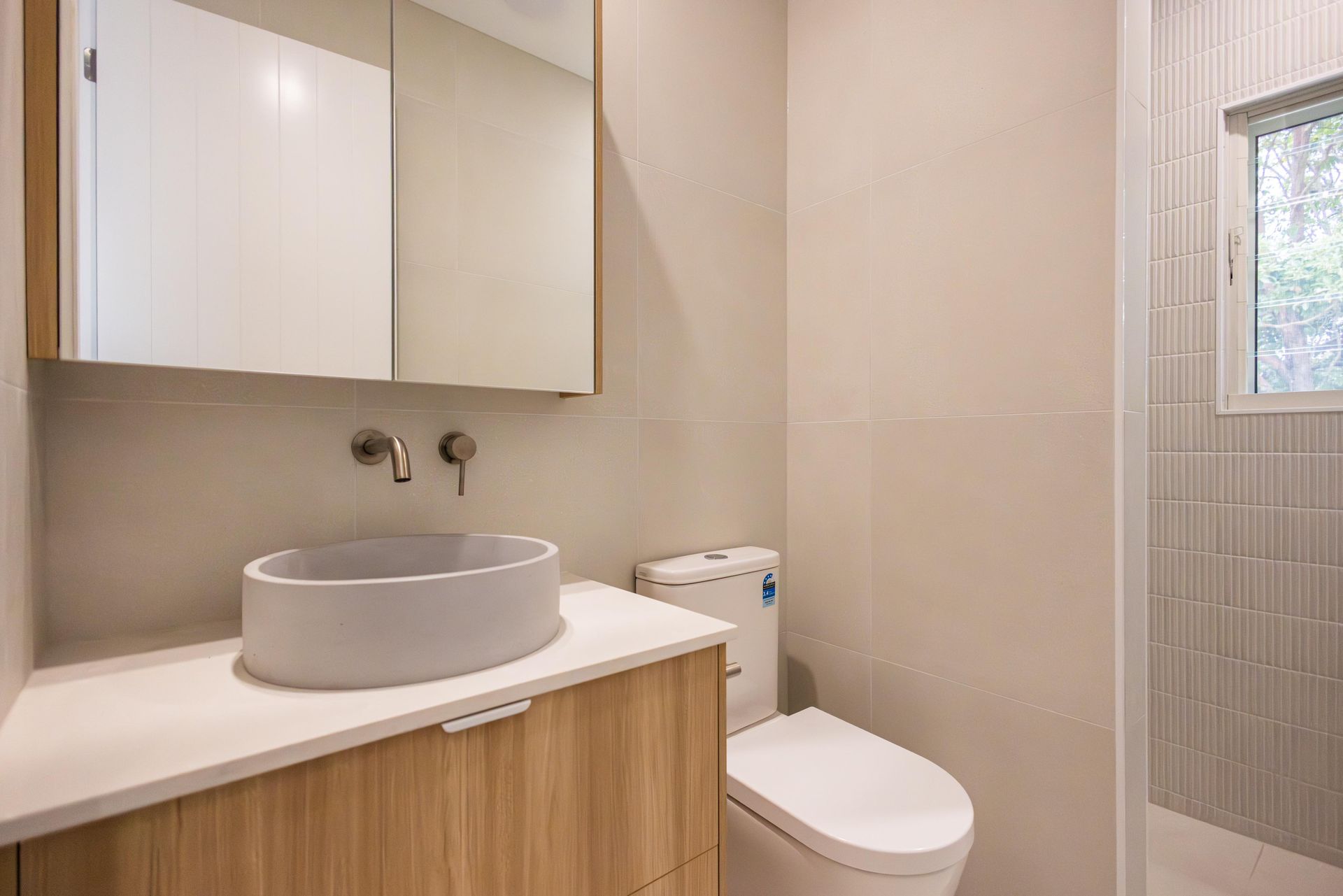 A bathroom with a sink , toilet and mirror.