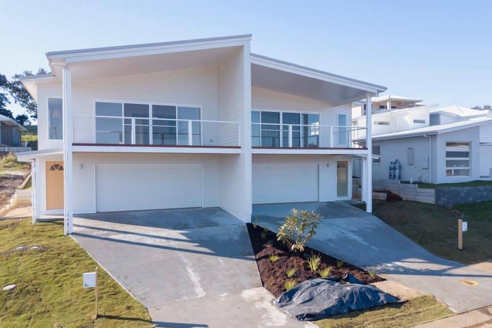 A large white house with a lot of windows and a driveway.