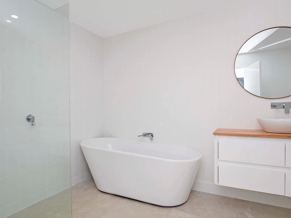 A bathroom with a bathtub , sink and shower.