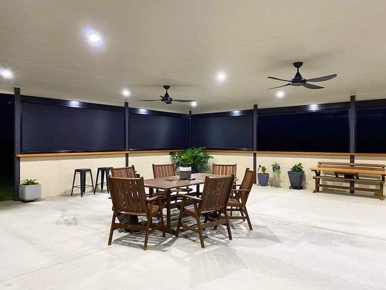 A patio with a table and chairs and a ceiling fan.